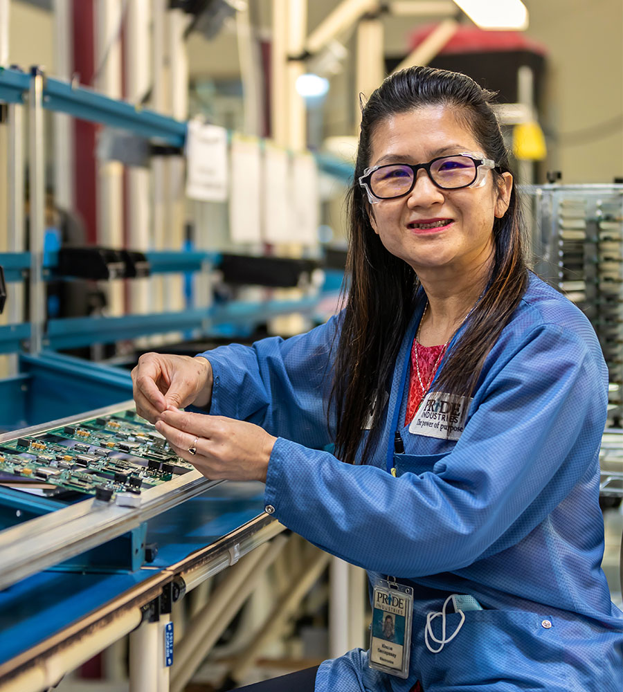 image of woman in glasses working on electronics parts