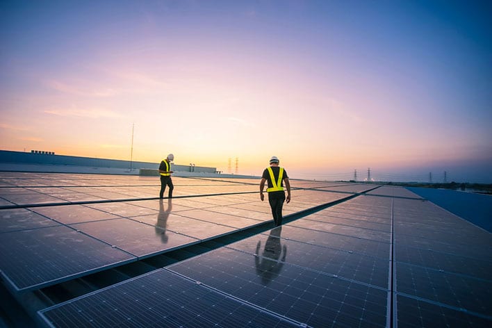 two people inspecting solar panels