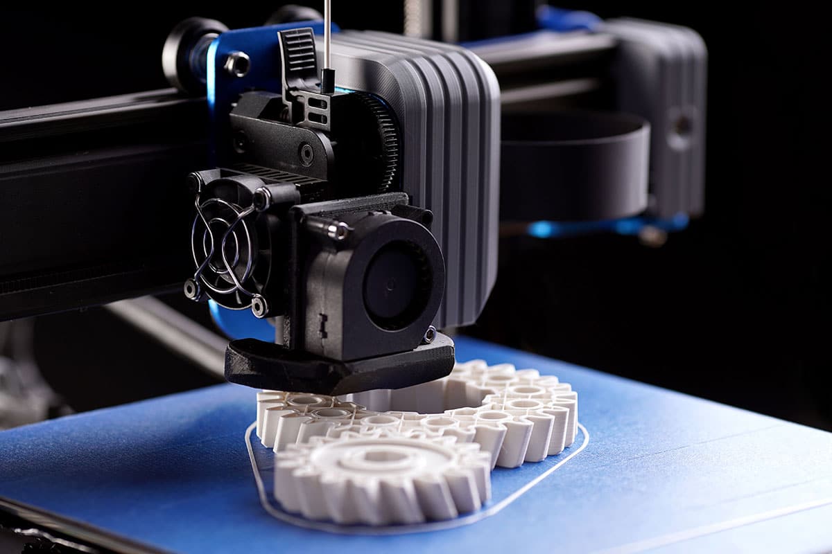 A 3D printing machine in action, making an electronics component or shell.