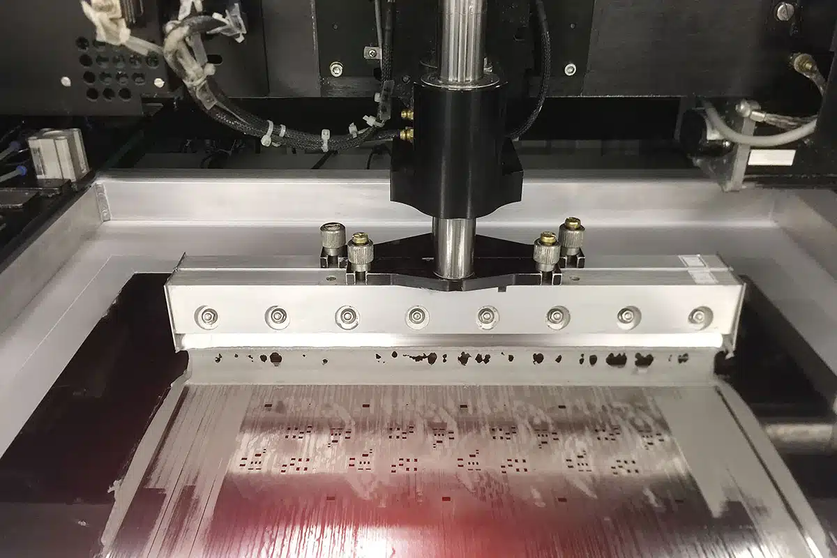 A solder paste printing machine deposits solder on a printed circuit board