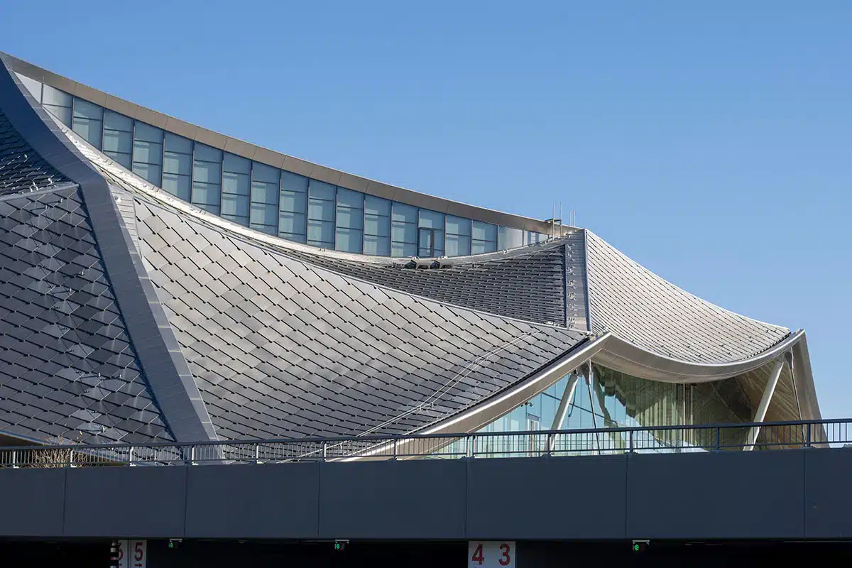 The curvy roof of a modern building, composed of tiles that integrate PV technology to capture solar energy